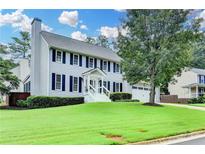 Charming two-story home with a well-manicured lawn, complemented by classic shutters and an inviting front porch at 939 Flowers Xing, Lawrenceville, GA 30044