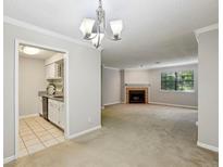 Bright living room with a fireplace, light gray walls, large windows, and access to the kitchen at 511 Barrington Hills Dr, Atlanta, GA 30350