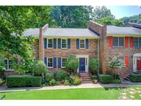 Charming brick townhome featuring colorful shutters and a beautifully landscaped front yard at 1105 Clairemont Ave # J, Decatur, GA 30030