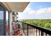 Condo balcony with rocking chairs and scenic views of trees and a parking lot at 795 Hammond Dr # 1012, Atlanta, GA 30328