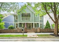 Charming two-story home with a welcoming front porch, fenced yard, and mature trees at 1622 Gates Nw Pl, Atlanta, GA 30318