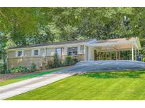 Charming single-story house with brick accents, covered parking, and lush green lawn at 8767 N View Dr, Lithia Springs, GA 30122