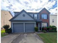 Charming two-story home with a two-car garage, manicured lawn, and tasteful brick and siding combination at 640 Dahoma Trl, Woodstock, GA 30188