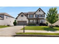 Charming two-story home featuring a brick and siding exterior, well-manicured lawn and a two-car garage at 5240 Bristlecone Pine Way, Cumming, GA 30040