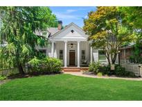 Charming white home featuring stately columns, a swing, and mature trees with a lush green lawn at 582 Lakeshore Ne Dr, Atlanta, GA 30307