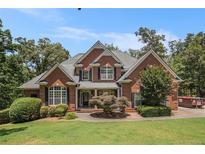 Charming brick home with manicured lawn, complemented by lush trees and mature landscaping at 6255 Hedgestone Way, Douglasville, GA 30135