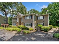 Traditional two-story townhouse featuring stone accents, black shutters, and mature trees at 1468 Briarwood Ne Rd # 406, Brookhaven, GA 30319