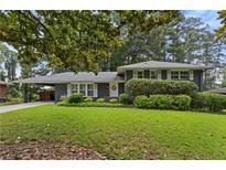 Charming home with a well-maintained front yard and a welcoming entrance with covered parking at 2416 Elmwood Se Cir, Atlanta, GA 30339