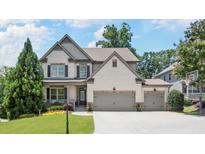 Charming two-story home with a manicured lawn, featuring a two-car garage and inviting front porch at 5605 Miners Rdg, Cumming, GA 30028