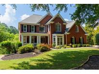 Charming two-story red brick home featuring a landscaped yard and welcoming front porch at 130 Hamilton Way, Roswell, GA 30075