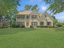 Charming two-story traditional home with a well-manicured lawn and lush greenery at 1525 Lake Dow Rd, Mcdonough, GA 30252