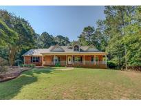 Charming brick home featuring a welcoming front porch and well-manicured lawn at 502 Brookline Pl, Mcdonough, GA 30252