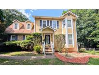 Charming two-story home with yellow siding, blue shutters, and well-maintained front yard at 75 Maygold St, Mcdonough, GA 30253
