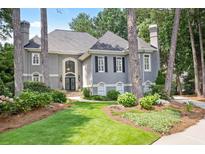 Charming two-story home boasts a landscaped front yard, mature trees, and a welcoming entrance at 1111 Waterford Green Pt, Marietta, GA 30068