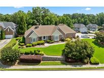 Well-maintained brick home with a manicured lawn and mature trees providing shade and curb appeal at 2012 Arbor Springs Way, Buford, GA 30519