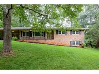 Charming brick home with a well-maintained lawn and mature trees provides comfortable living at 4852 Pine Shadows Dr, Stone Mountain, GA 30088