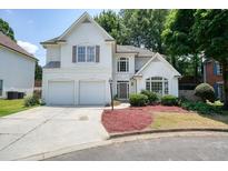 Charming stucco home with a two-car garage, manicured lawn, and inviting curb appeal at 1971 Wellesley Trce, Dunwoody, GA 30338