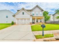 Charming two-story home featuring a well-maintained lawn, a two-car garage, and inviting curb appeal at 2102 Black Pebble Cir, Buford, GA 30519