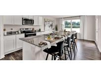 Modern kitchen with granite countertops, stainless steel appliances, and an island with bar stool seating at 5453 Baybrook Cir, South Fulton, GA 30349