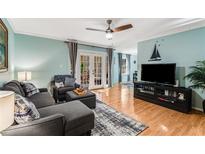 Cozy living room features hardwood floors, ceiling fan, and access to a balcony at 1445 Monroe Ne Dr # F12, Atlanta, GA 30324