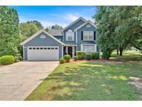 Charming blue two-story home with well-manicured lawn and attached two-car garage in a desirable neighborhood at 254 Wood Duck Dr, Jonesboro, GA 30238