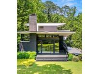 Stunning modern home surrounded by lush greenery with sleek lines and expansive windows at 3891 Wieuca Rd, Atlanta, GA 30342