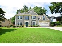 Charming two-story home features a well-manicured lawn and attached two car garage at 340 Channings Lake Dr, Lawrenceville, GA 30043