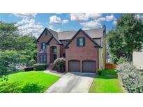 Charming brick two-story home with two-car garage and well-manicured front lawn at 350 River Walk Ter, Johns Creek, GA 30024