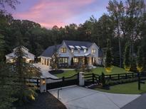 Stunning two-story home with manicured lawn, black gated entrance, and a detached garage with an extra four-car garage at 504 Trinity Church Rd, Canton, GA 30115