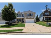 Charming two-story home with a well-manicured lawn, two-car garage, and classic brick facade at 320 Pebblestone Ln, Canton, GA 30115