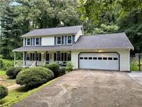 Charming two-story home with a front porch, attached garage and well-manicured landscaping at 460 Heathrow Way, Stone Mountain, GA 30087