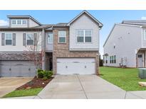 Charming townhome with a two-car garage and manicured front lawn at 2231 Bedell Dr, Conyers, GA 30094
