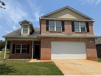 Charming two-story brick home with a well-manicured lawn and attached two car garage at 425 Bell Flower Trl, Locust Grove, GA 30248