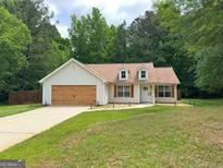 Charming single-story home featuring a well-maintained front lawn, dormer windows, and attached garage at 106 Kimbell Farm Dr, Locust Grove, GA 30248