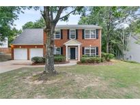 Charming two-story brick home featuring a two-car garage and well-manicured front lawn at 2683 Berry Ridge Ct, Buford, GA 30519