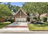Charming brick home with mature trees, two-car garage and manicured landscaping at 35 Westfair Ct, Atlanta, GA 30328