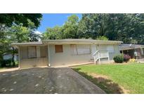 Ranch home with a painted brick facade, covered front porch, and mature trees at 2083 Meador Se Ave, Atlanta, GA 30315