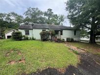 Quaint single-story home with light green siding and mature trees at 4125 N Dearing Ne St, Covington, GA 30014