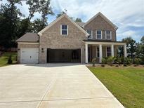 Beautiful two-story brick home with a spacious driveway and a charming front porch at 6945 Melody Ridge Rd, Buford, GA 30518