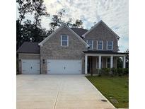 Charming two-story brick home with a three-car garage and a well-manicured lawn at 6945 Melody Ridge Rd, Buford, GA 30518