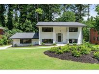 Charming two-story home featuring black window shutters, a landscaped yard, and a well-manicured lawn at 2550 Laurel Ridge Dr, Decatur, GA 30033