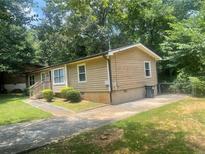 Charming single-story home with tan siding, landscaped yard, and paved driveway at 4434 Janice Dr, Snellville, GA 30039