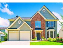 Charming two-story home with a well-manicured lawn, an attached two-car garage, and a beautiful brick facade at 560 Edgehill Pl, Johns Creek, GA 30022