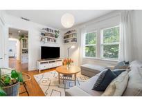 Bright living room with a modern design, floating bookshelves, and a comfortable gray sectional at 830 Barnett Ne St # 2, Atlanta, GA 30306