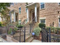 Charming brick townhome with wrought iron railings and landscaped front yard at 328 Brownstones Cir, Atlanta, GA 30312