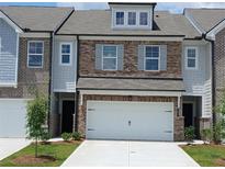 Charming townhome featuring a two-car garage, brick accents, and well-maintained landscaping at 545 Tuskegee St # 50, Mcdonough, GA 30252
