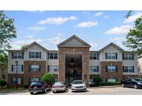 Exterior shot of the apartment building, showing the parking lot and some parked cars at 3303 Par Three Way, Lithonia, GA 30038