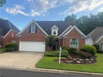 Charming brick home featuring an attached garage, manicured lawn, and mature landscaping at 3812 Mine Creek Ln, Marietta, GA 30062