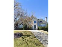 Charming two-story home with a manicured front yard and a curved driveway at 12120 Meadows Ln, Alpharetta, GA 30005