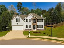 Charming two-story home featuring a well-manicured lawn, two-car garage, and a stone-accented entryway at 3554 Cherry Bloom Way, Decatur, GA 30034